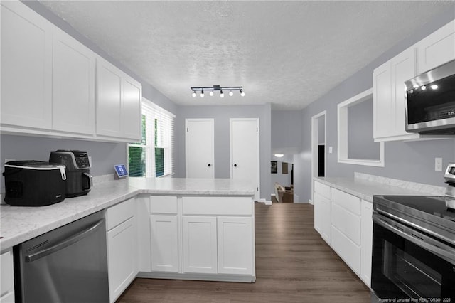 1618 Hickory Ridge Ct, Fayetteville, NC 28304 - kitchen featuring stainless steel appliances, a peninsula, white cabinetry, dark wood-style floors, and a textured ceiling
