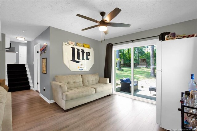 1618 Hickory Ridge Ct, Fayetteville, NC 28304 - living room featuring wood finished floors, a ceiling fan, a textured ceiling, baseboards, and stairway