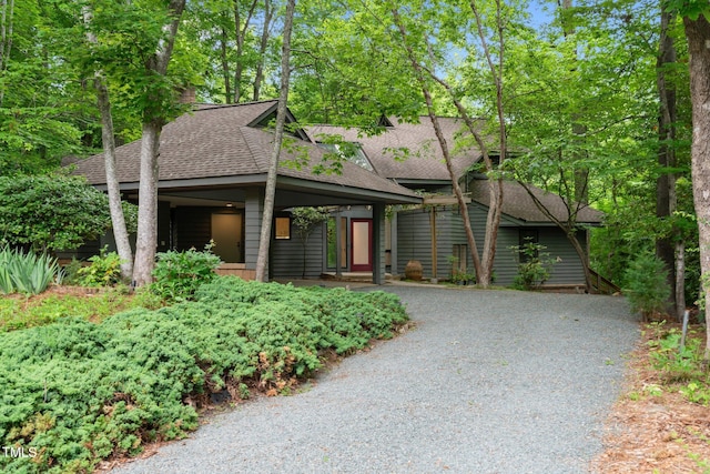 view of front facade with roof with shingles and driveway