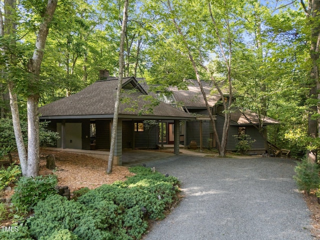 view of front of home featuring roof with shingles and driveway