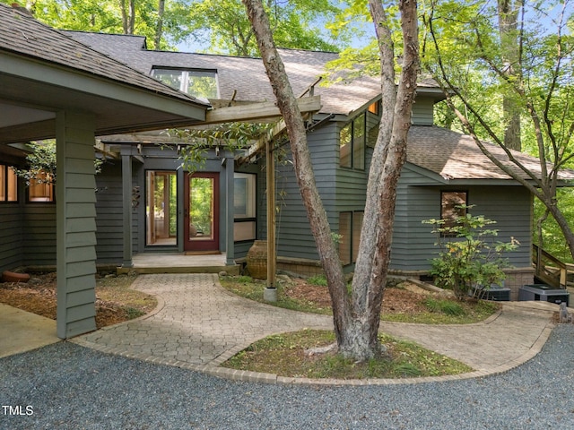 property entrance featuring roof with shingles