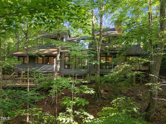 rear view of property with a porch and a chimney