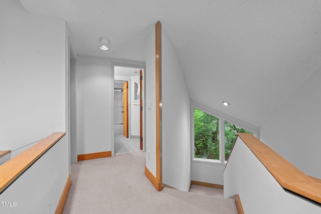 hallway featuring baseboards, light colored carpet, and recessed lighting