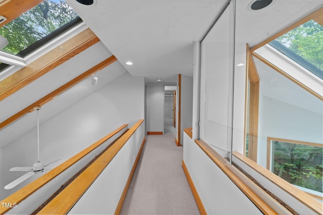 hall with light carpet, baseboards, vaulted ceiling, and recessed lighting