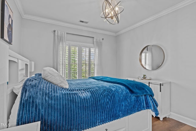 bedroom featuring wood finished floors, ornamental molding, baseboards, and a chandelier