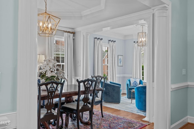 dining space featuring a chandelier, wood finished floors, and baseboards