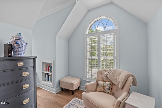 sitting room with lofted ceiling, light wood-style flooring, and baseboards