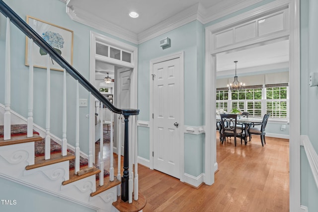 entrance foyer with stairway, light wood-type flooring, ceiling fan, ornamental molding, and baseboards