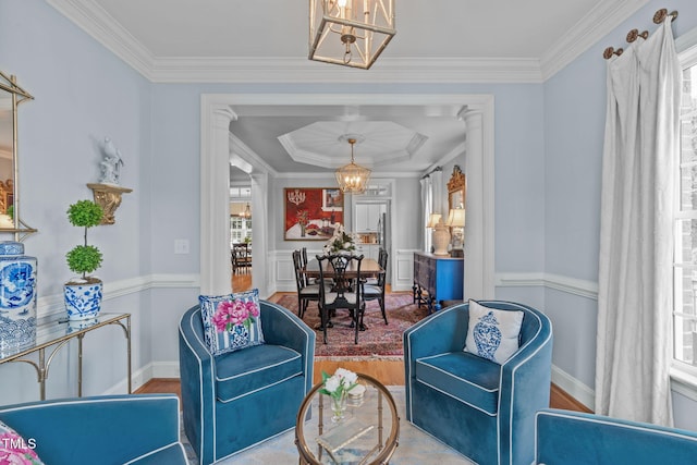 living area featuring a chandelier, wood finished floors, crown molding, and baseboards