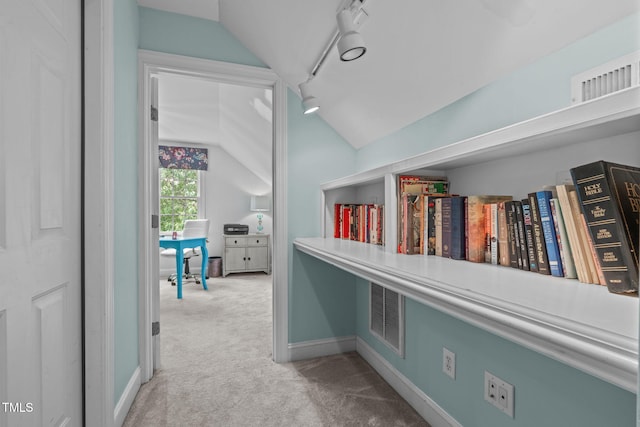 hall featuring lofted ceiling, carpet, baseboards, and an office area