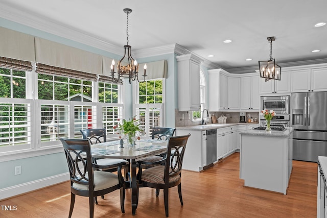 dining room with a chandelier, crown molding, light wood-style floors, recessed lighting, and baseboards