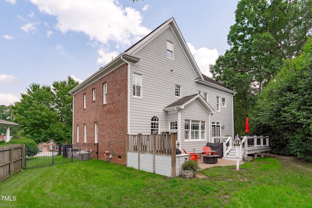 rear view of house with a wooden deck, an outdoor fire pit, central AC, and brick siding