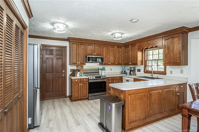 kitchen featuring a sink, a peninsula, stainless steel appliances, a textured ceiling, and light countertops