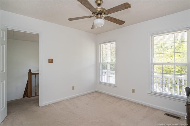 unfurnished room with baseboards, light carpet, and visible vents