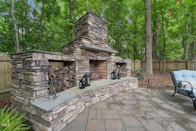 325 Wescott Ridge Dr, Holly Springs, NC 27540 - fenced backyard with an outdoor stone fireplace and a patio area