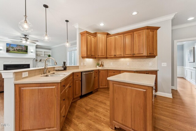325 Wescott Ridge Dr, Holly Springs, NC 27540 - kitchen with stainless steel dishwasher, light wood-type flooring, a fireplace, light countertops, and ornamental molding