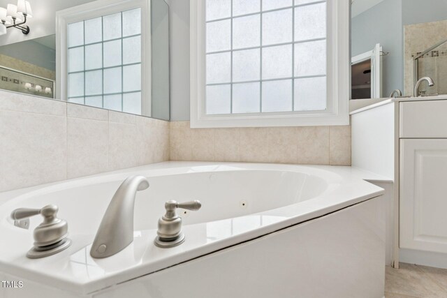 325 Wescott Ridge Dr, Holly Springs, NC 27540 - bathroom featuring a shower stall, a whirlpool tub, tile patterned flooring, and a chandelier