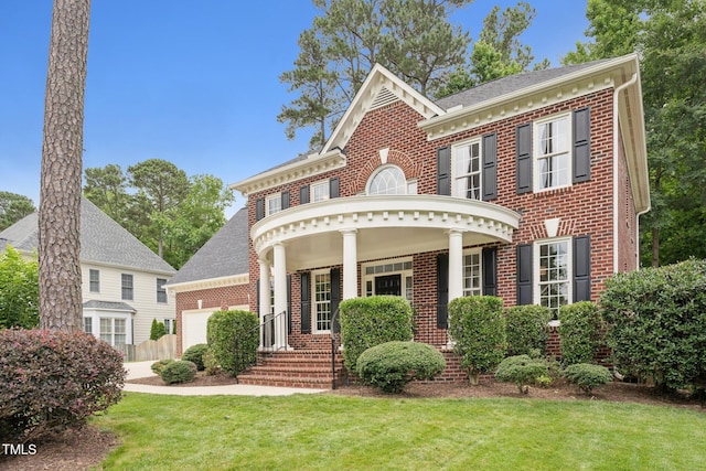 325 Wescott Ridge Dr, Holly Springs, NC 27540 - colonial house with brick siding, an attached garage, a front lawn, a porch, and roof with shingles