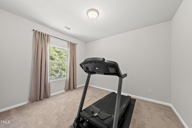 workout area featuring light colored carpet and baseboards