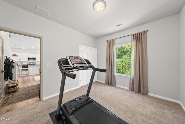 workout area featuring carpet floors and baseboards