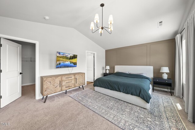 bedroom featuring lofted ceiling, carpet floors, a chandelier, a spacious closet, and a closet