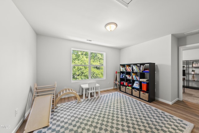 rec room featuring wood finished floors and baseboards