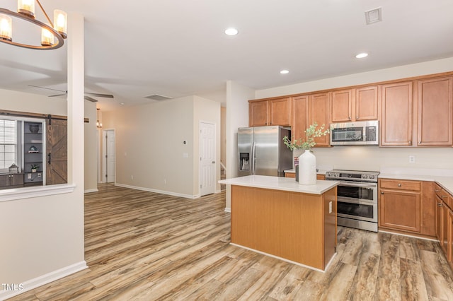 12340 Tetons Ct, Durham, NC 27703 - kitchen with appliances with stainless steel finishes, light wood-style floors, a kitchen island, light countertops, and recessed lighting