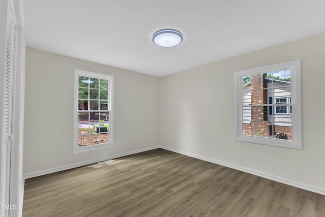 spare room featuring wood finished floors and baseboards