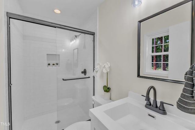 bathroom with toilet, a shower stall, vanity, and recessed lighting