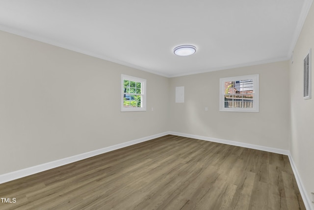 unfurnished room featuring crown molding, wood finished floors, and baseboards