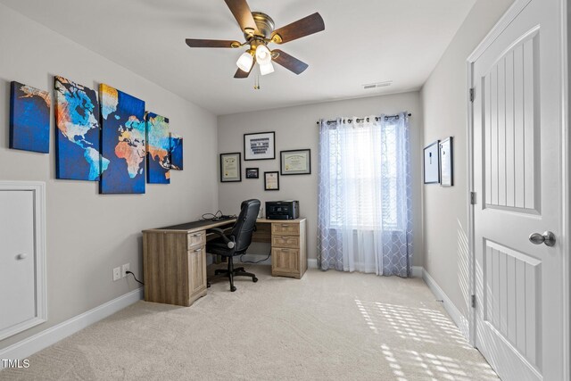 office area with a ceiling fan, light carpet, and baseboards