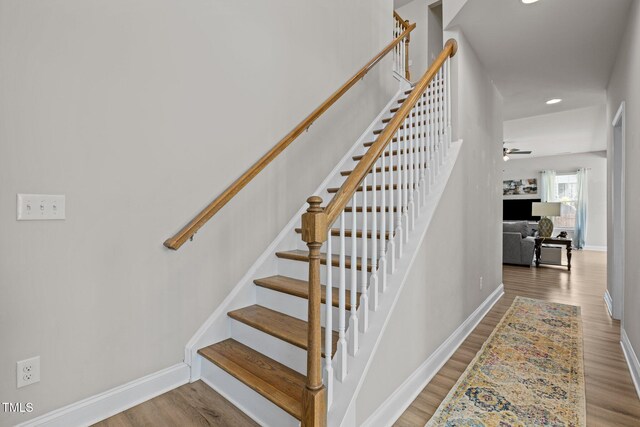 stairway featuring baseboards, a ceiling fan, recessed lighting, and wood finished floors