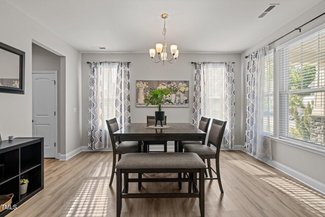 dining area with plenty of natural light, baseboards, and a chandelier