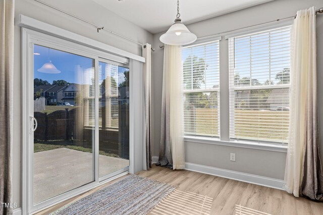 unfurnished dining area with wood finished floors and baseboards
