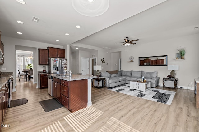 kitchen featuring stainless steel appliances, light wood-style flooring, light stone counters, recessed lighting, and baseboards