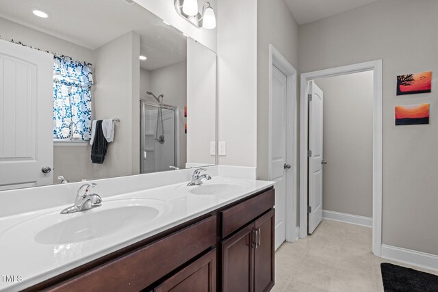full bath with a shower stall, double vanity, and baseboards