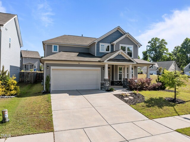 craftsman-style home featuring a porch, an attached garage, and driveway