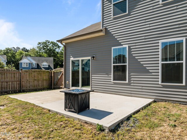 rear view of house featuring a patio and a fire pit
