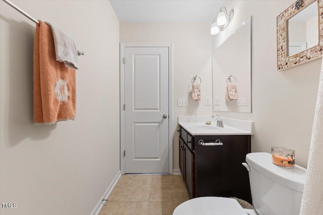 bathroom featuring toilet, vanity, baseboards, and tile patterned floors
