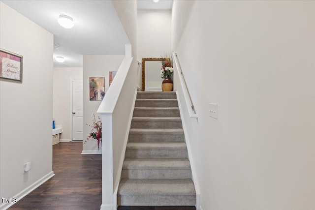 stairway with wood finished floors and baseboards