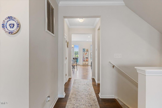 hall featuring dark wood-type flooring, an upstairs landing, baseboards, and ornamental molding
