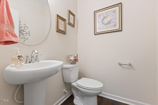 bathroom featuring baseboards, toilet, and wood finished floors