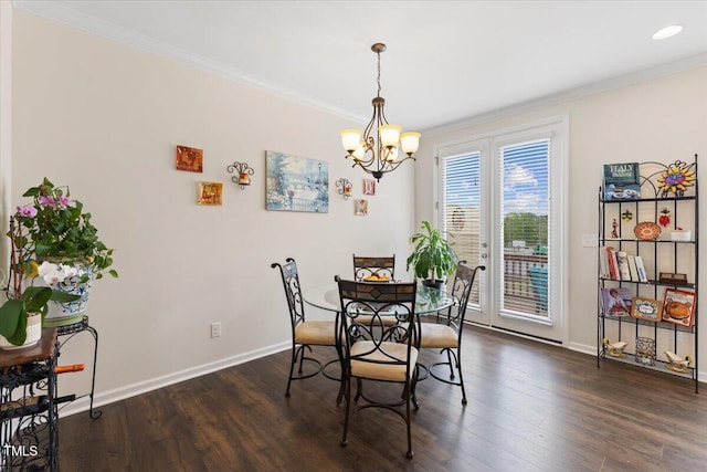 dining space with crown molding, baseboards, dark wood finished floors, and a chandelier