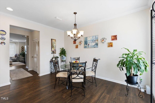 dining room with wood finished floors, a chandelier, crown molding, and baseboards