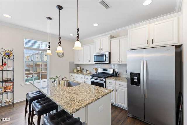 kitchen with stainless steel appliances, a sink, white cabinets, decorative backsplash, and dark wood-style floors