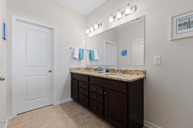 full bath with baseboards, double vanity, and tile patterned floors