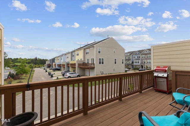 wooden terrace with a residential view and grilling area