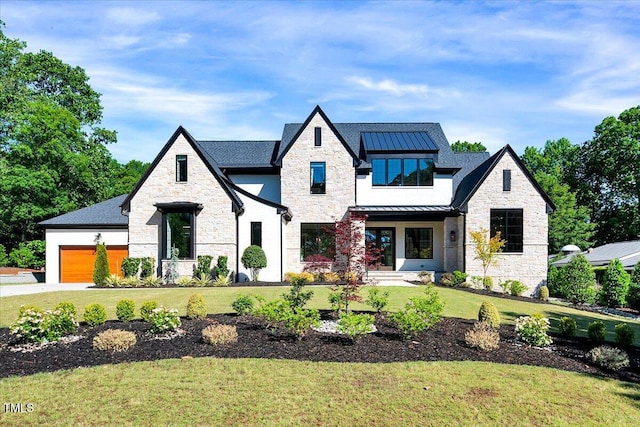 view of front of home featuring stone siding, a standing seam roof, a front lawn, and an attached garage