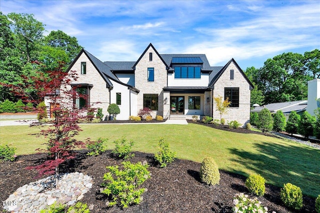 view of front of house featuring stone siding, a standing seam roof, a front yard, and metal roof