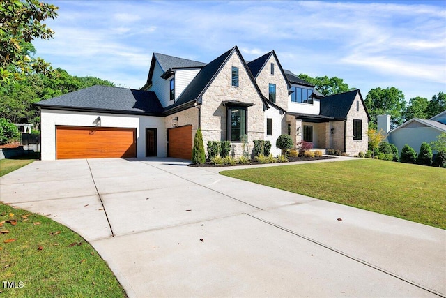 view of front of property featuring stone siding, a front yard, driveway, and a garage
